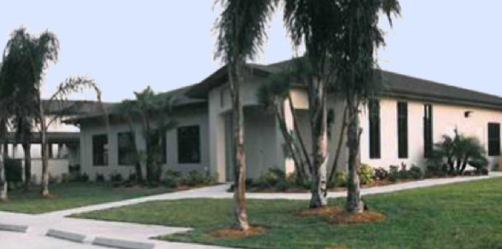 The Carriage Gate building, a single-story office lined with palm trees