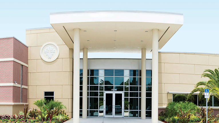 Columned entrance of CCM's Melbourne, Florida headquarters, with the ministry's logo on the wall